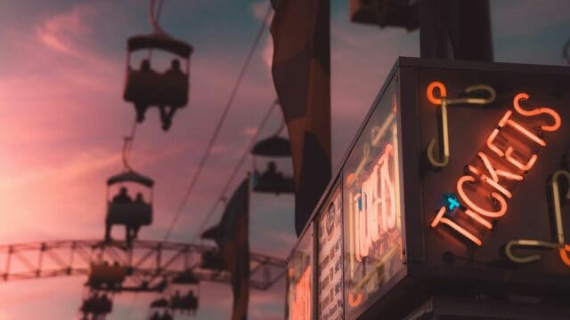 Cable car silhouettes and neon ticket sign at sunset